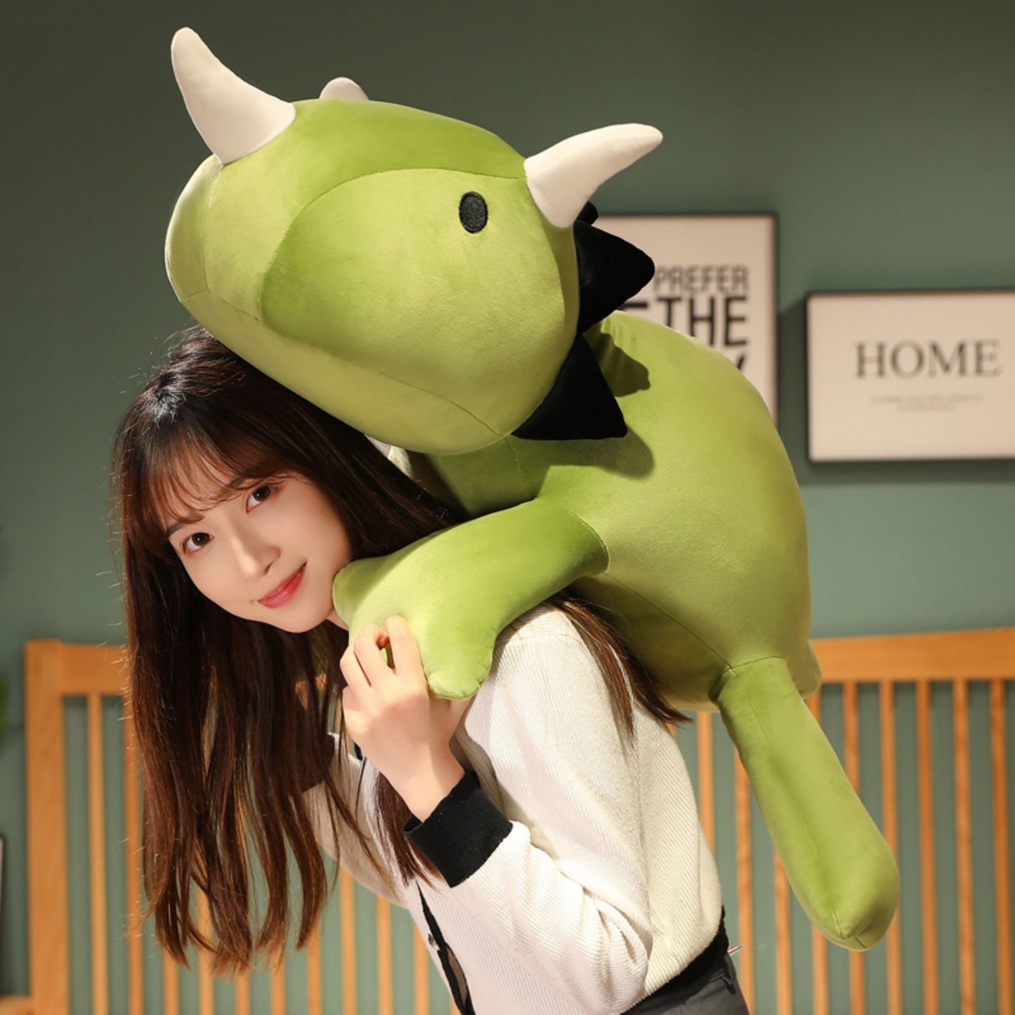 SQEQE giant triceratops stuffed animal shown with smaller matching plush toys in a bedroom