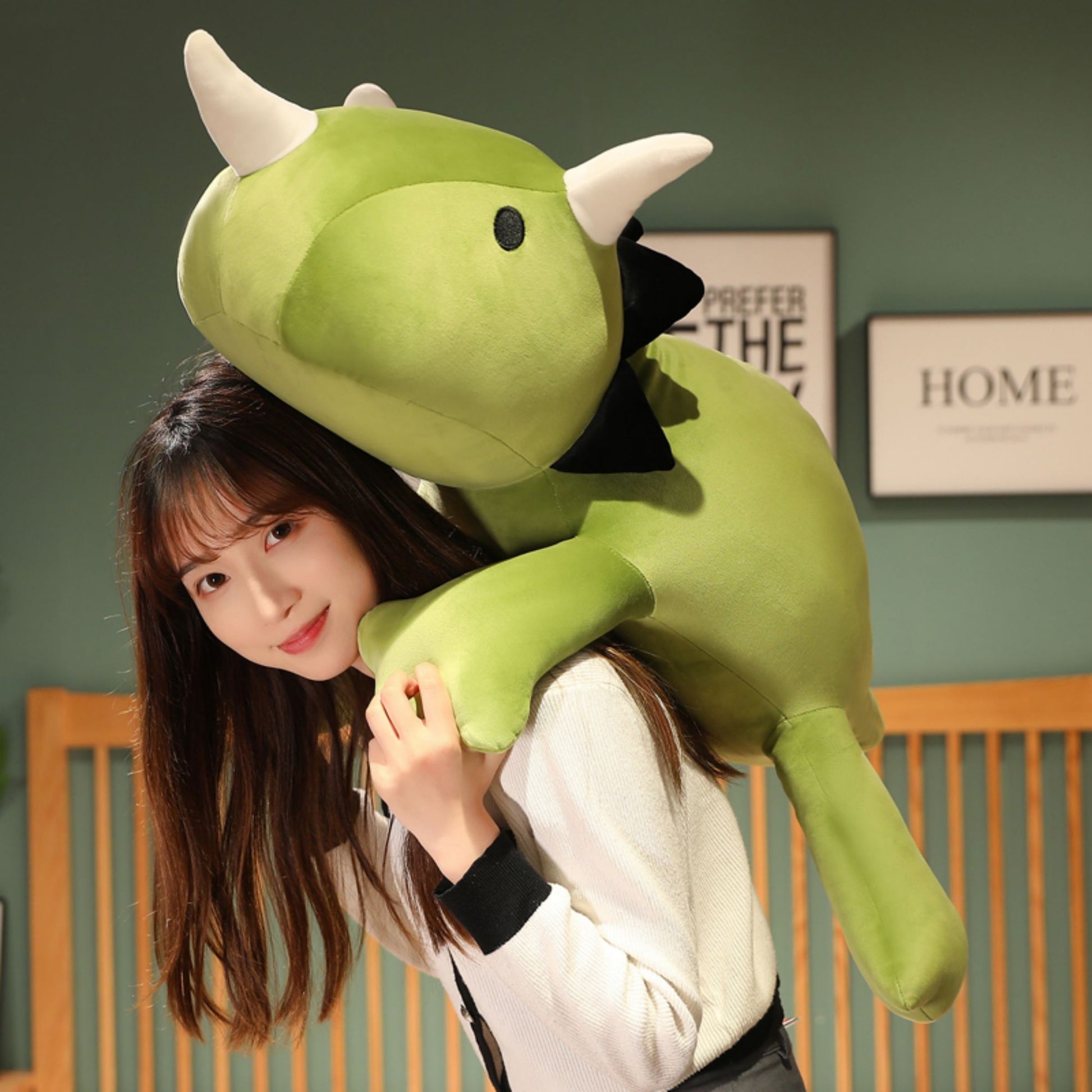 SQEQE giant triceratops stuffed animal shown with smaller matching plush toys in a bedroom
