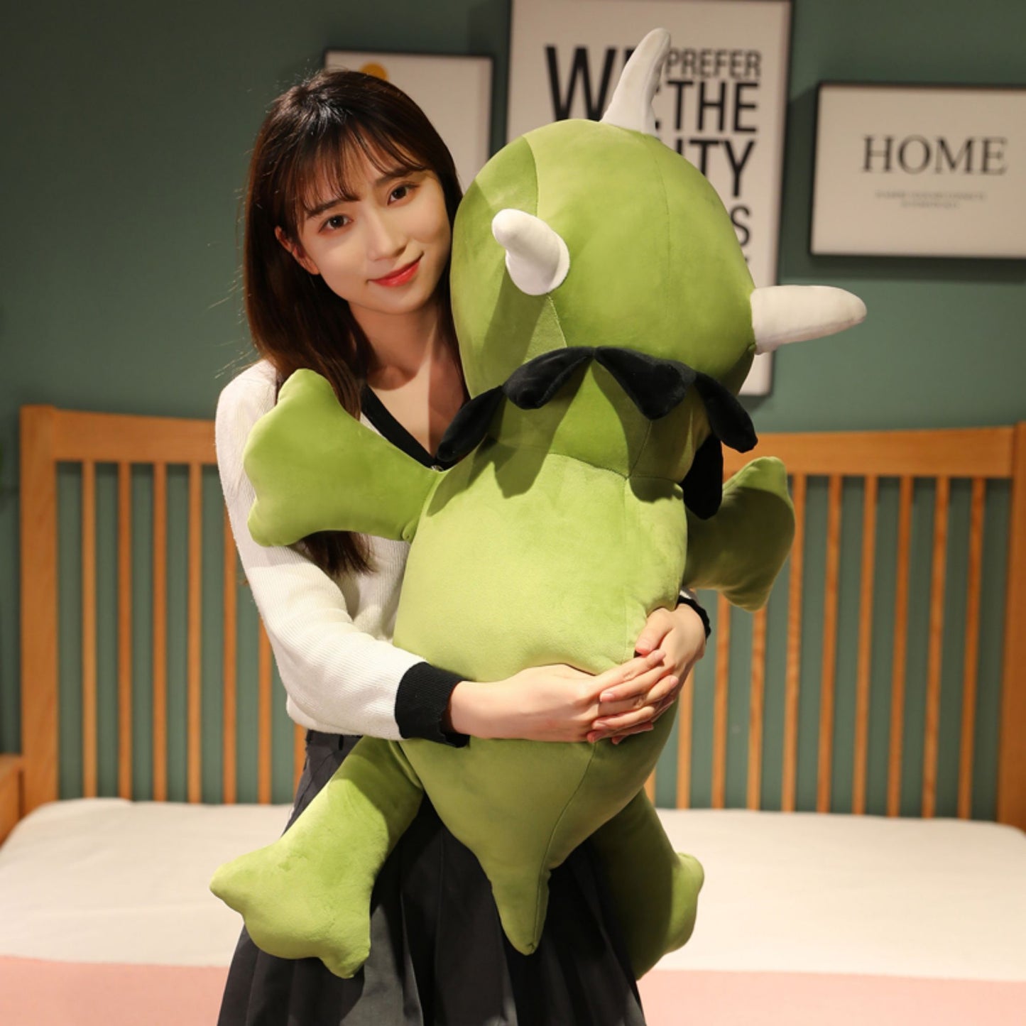 SQEQE giant triceratops stuffed animal hugged by an adult at a desk