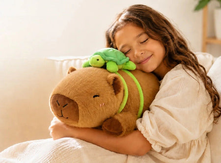 Child cuddling a brown capybara stuffed animal while relaxing on a sofa